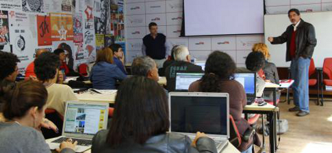 Formação e Debate: Participantes com Laptops em Sala de Aula