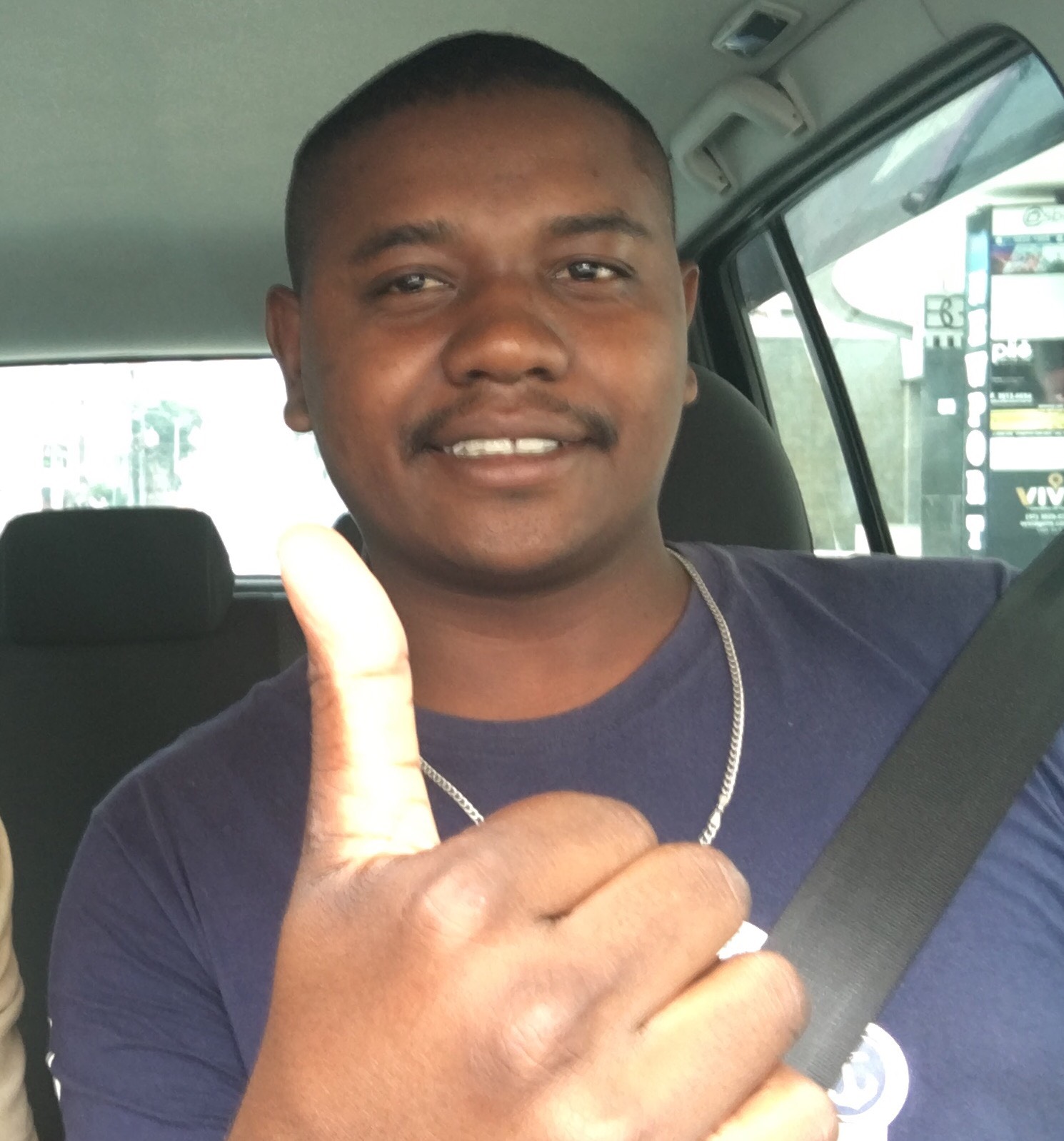 Homem Feliz no Carro Faz Sinal de Positivo
