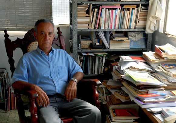 Pensador em seu escritório, cercado por livros e documentos.