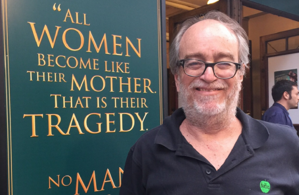 Homem sorridente e letreiro com citação sobre mulheres e mães