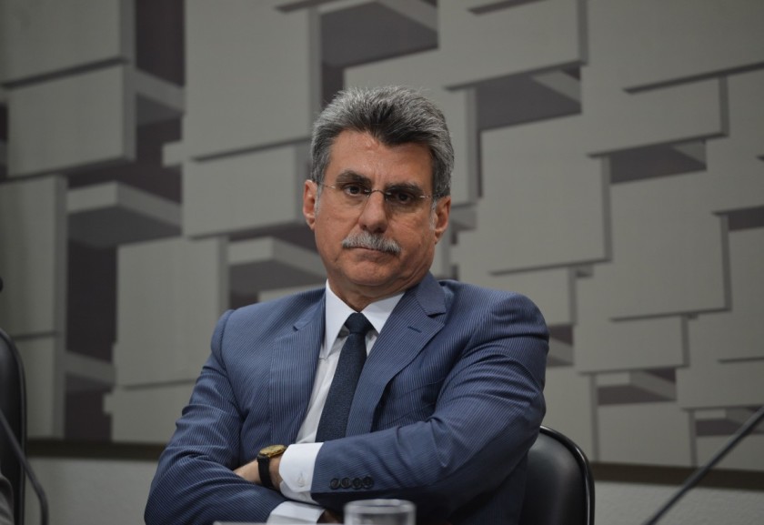 Homem em Terno com Expressão Séria em Contexto Institucional