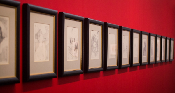 Galeria de Arte: Desenhos Enquadrados em Parede Vermelha