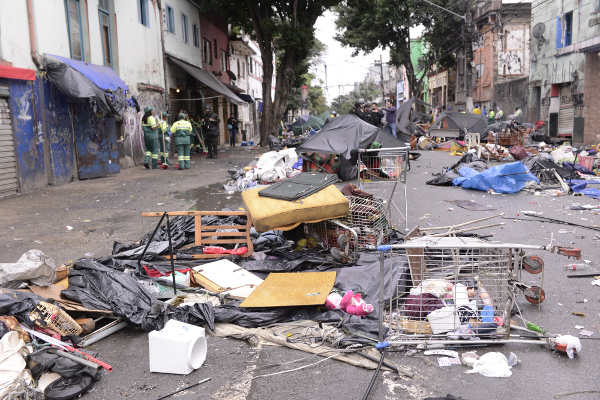 Rua com lixo, pertences e equipe de limpeza em São Paulo