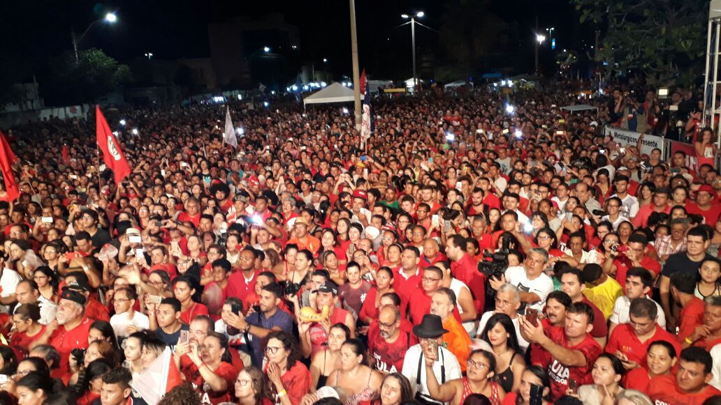 Multidão vermelha em ato político noturno: Lula presente.