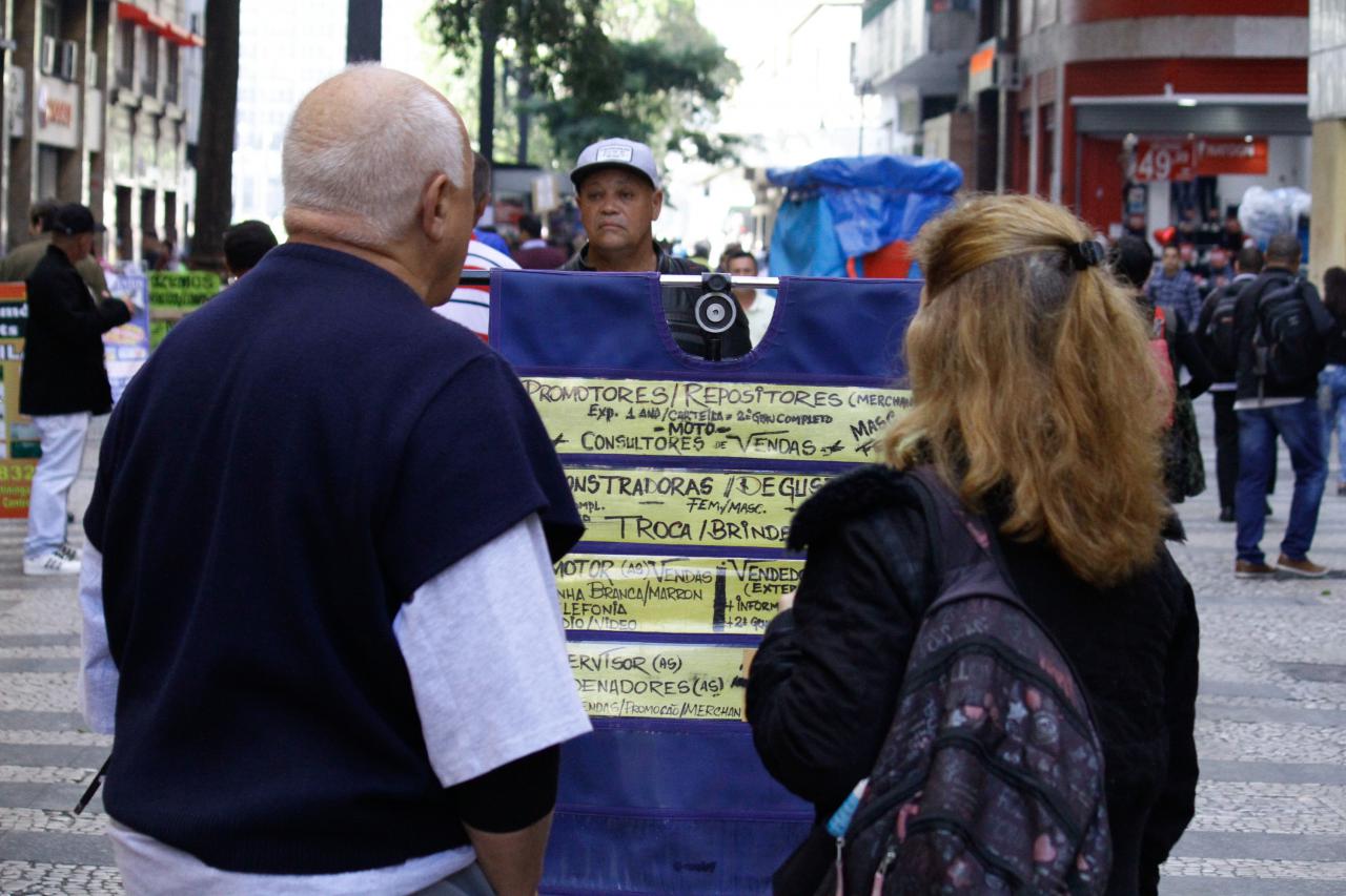 Pessoas Buscam Emprego Informal em Rua Urbana