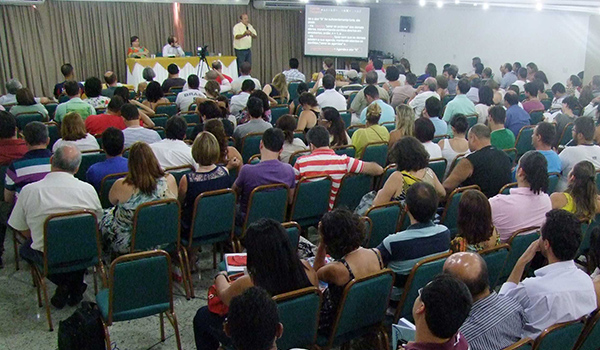 Conferência: Audiência atenta e palestrante ativo.