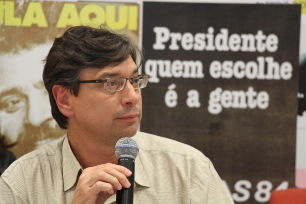 Homem com microfone e cartaz "Presidente quem escolhe é a gente"