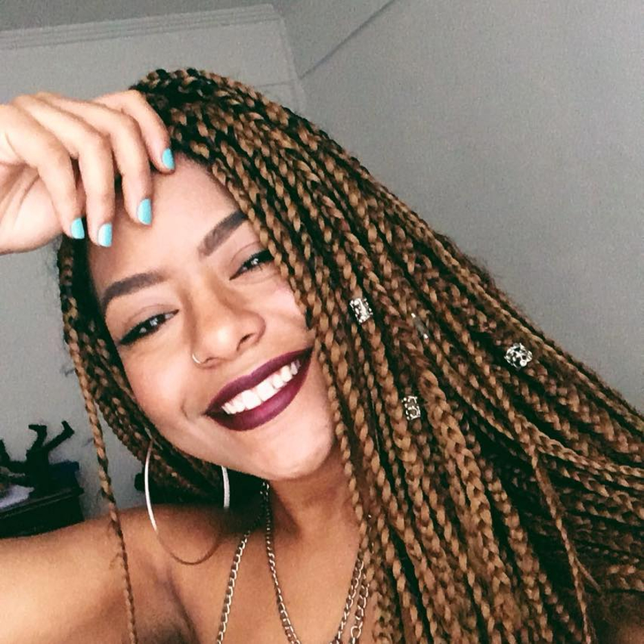 Mulher Negra Sorridente com Box Braids e Estilo Moderno