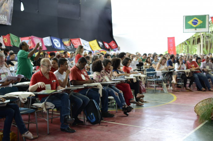 Audiência engajada em evento político-social com bandeiras