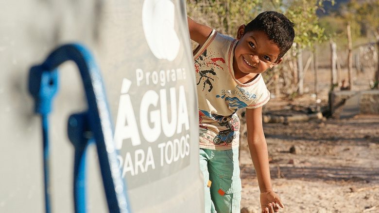 Criança sorridente com acesso à água potável no Brasil