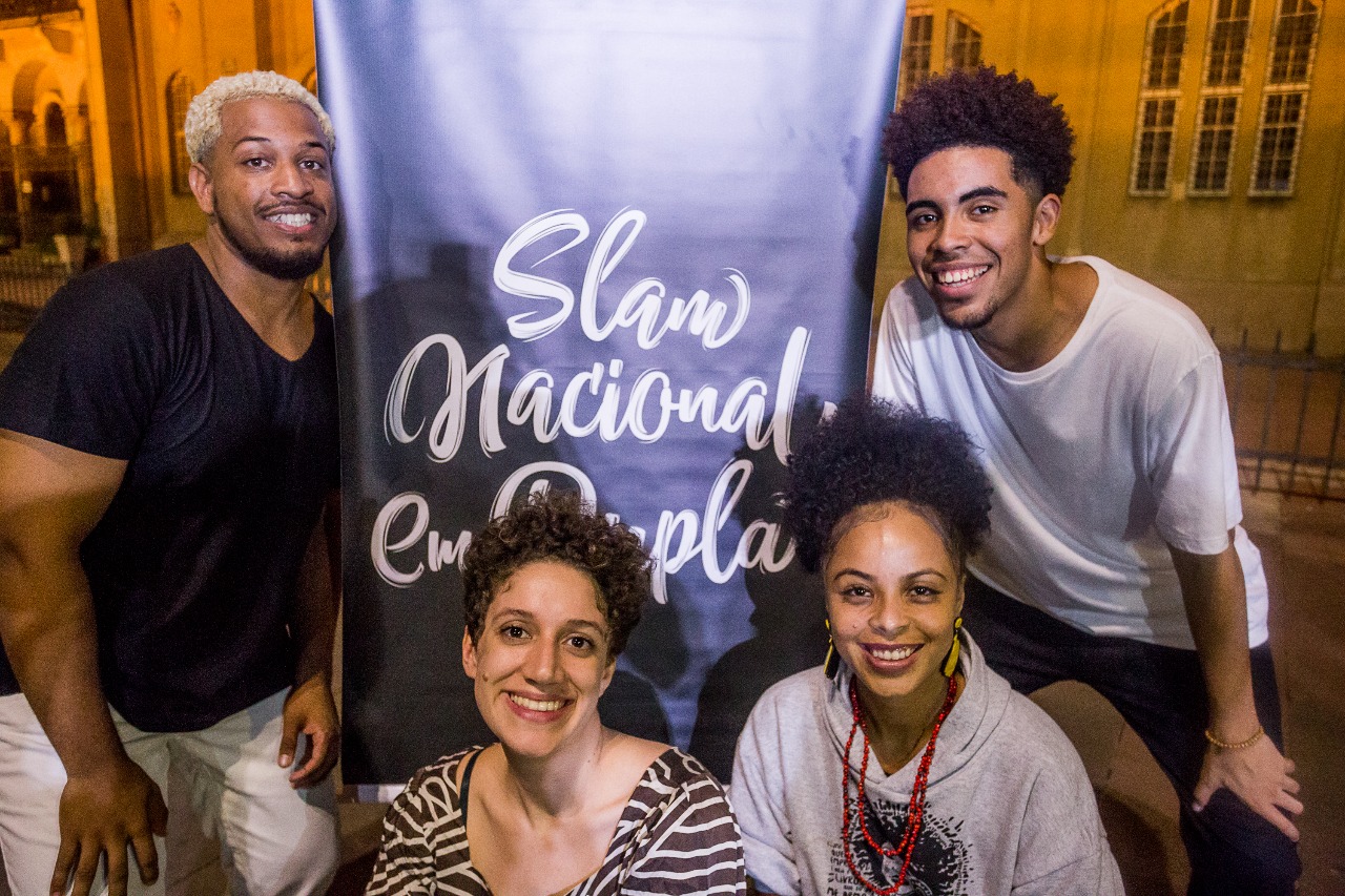 Jovens sorrindo em evento "Slam Nacional Em Dupla"