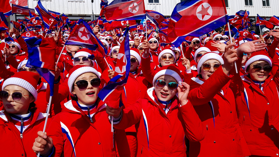 Multidão entusiasmada agita bandeiras da Coreia do Norte