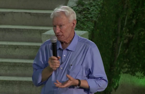 Homem discursando com microfone em evento