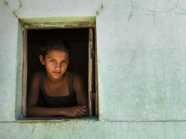 Jovem Garota na Janela: Olhar Contemplativo e Resiliente