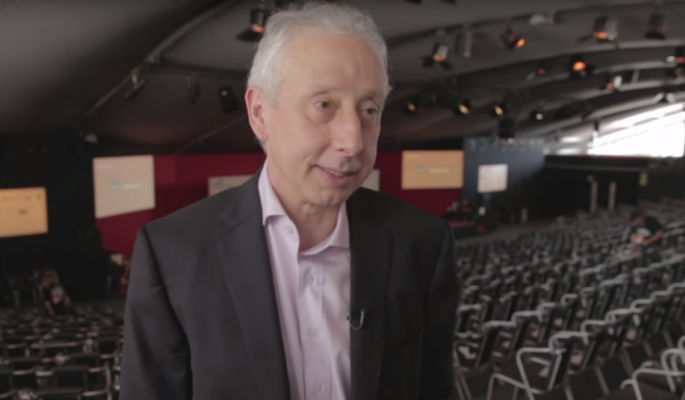 Homem em terno em auditório, evento ou conferência.