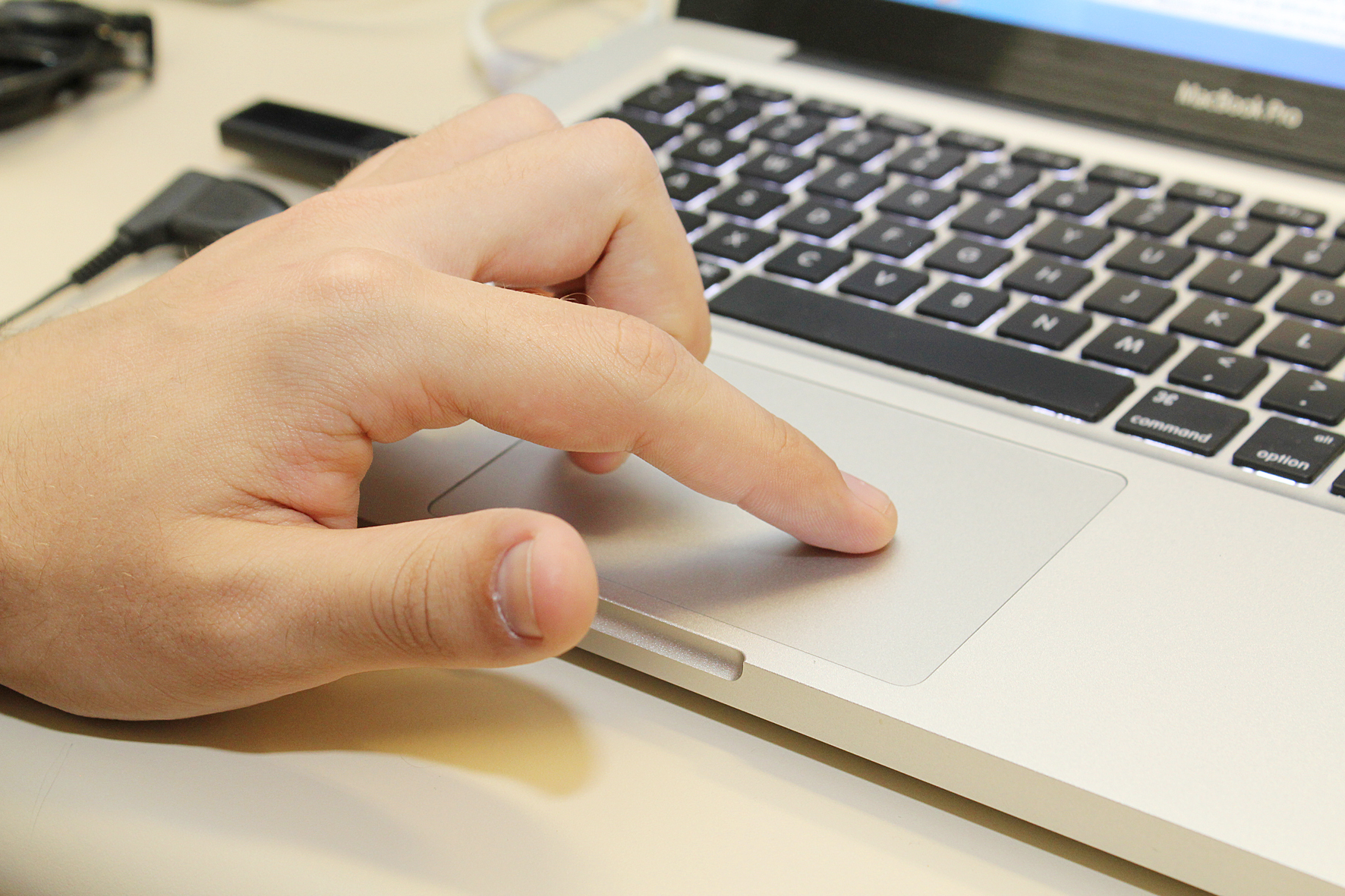 Mão operando trackpad de notebook