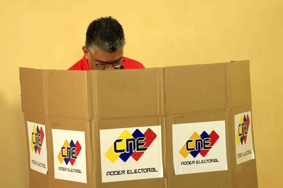 Eleitor em cabine de votação CNE: Democracia em ação