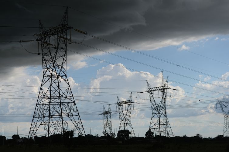 Torres de Energia sob Céu Contrastante: Tempestade e Clareza