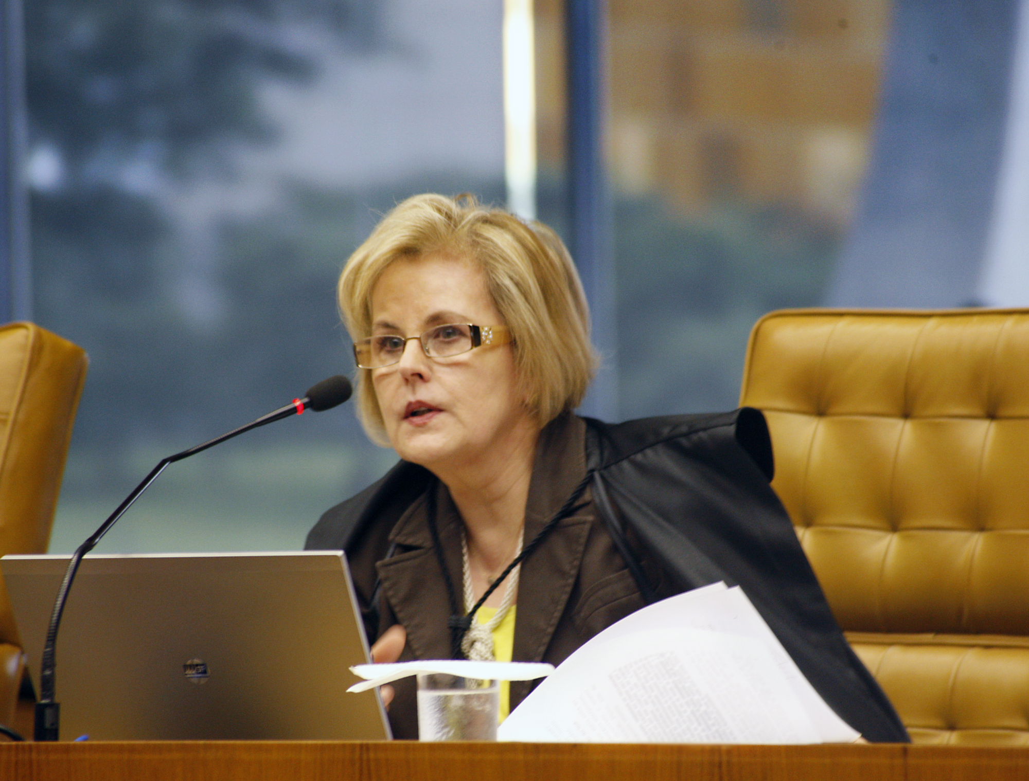 Palestrante mulher em evento formal com laptop