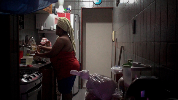 Mulher em tarefas domésticas, retrato do cotidiano na cozinha
