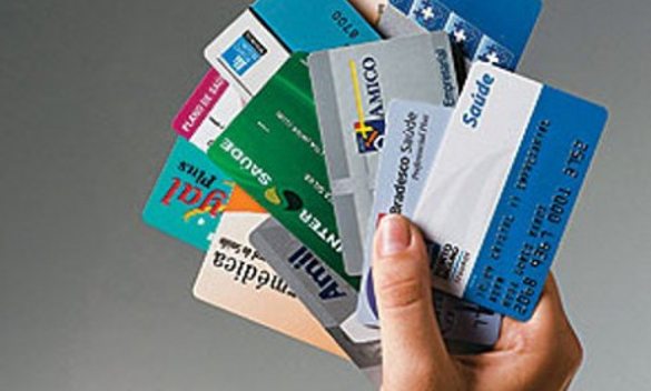 Mão Segurando Vários Cartões de Planos de Saúde