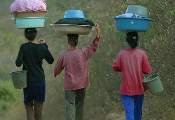 Mulheres Carregando Bacias e Baldes em Caminho Rural