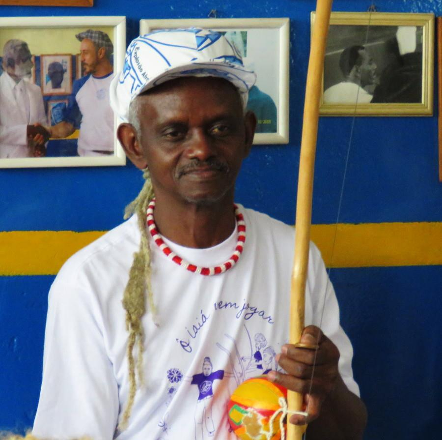 Capoeirista sorridente com berimbau, celebração da cultura afro-brasileira.