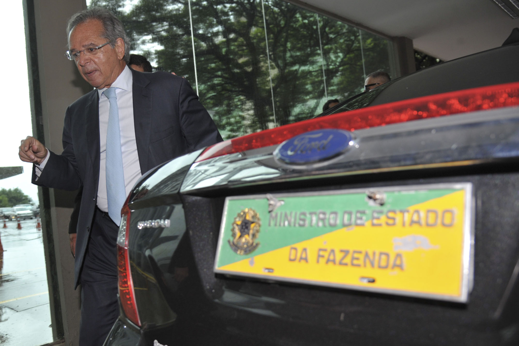 Ministro de Estado da Fazenda ao lado de carro Ford.