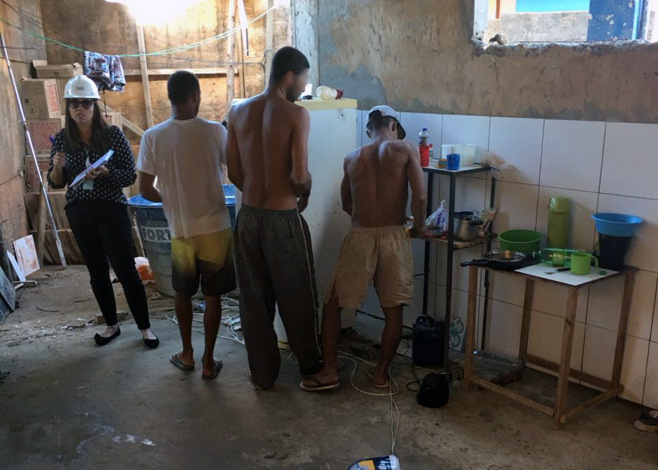 Mulher com capacete avalia condições de moradia e trabalho