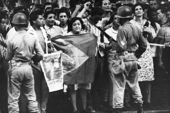 Tensão e Protesto: Civis com Bandeira do Brasil frente a Militares