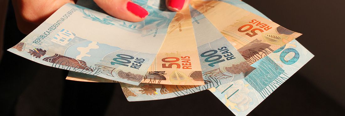 Dinheiro e economia brasileira na mão.