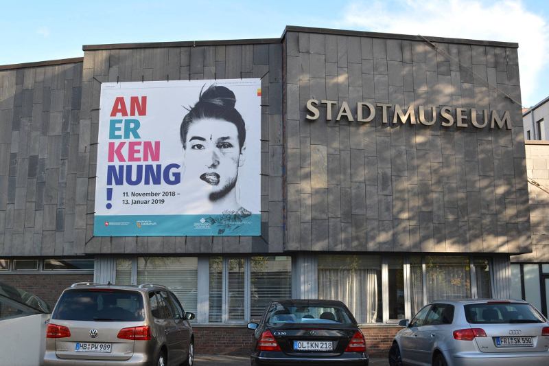 Stadtmuseum: Exposição "Anerkennung" com retrato artístico em destaque.