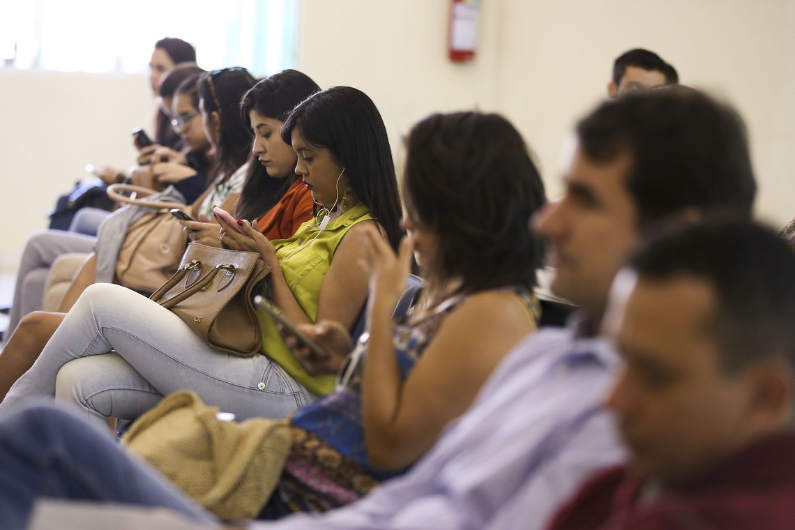 Pessoas Usando Smartphones em Evento: Distração Digital Coletiva