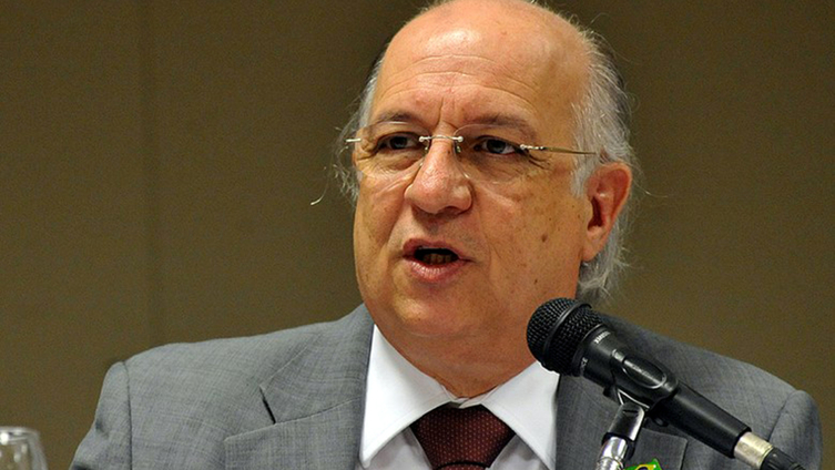 Homem de Terno Discursando ao Microfone em Evento Formal