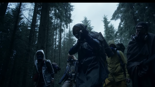 Grupo em Máscaras de Gás Caminha por Floresta Escura