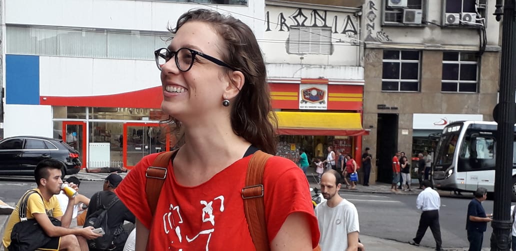 Jovem mulher sorridente em rua movimentada urbana