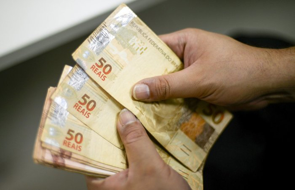 Mãos Contando Notas de 50 Reais Brasileiros