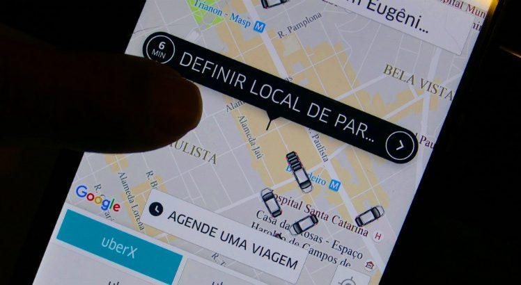 Mão Usando App Uber em Celular: Definindo Localização.