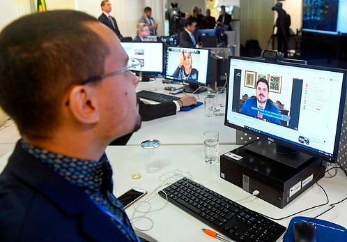 Homem em videoconferência sobre anistia e política digital.