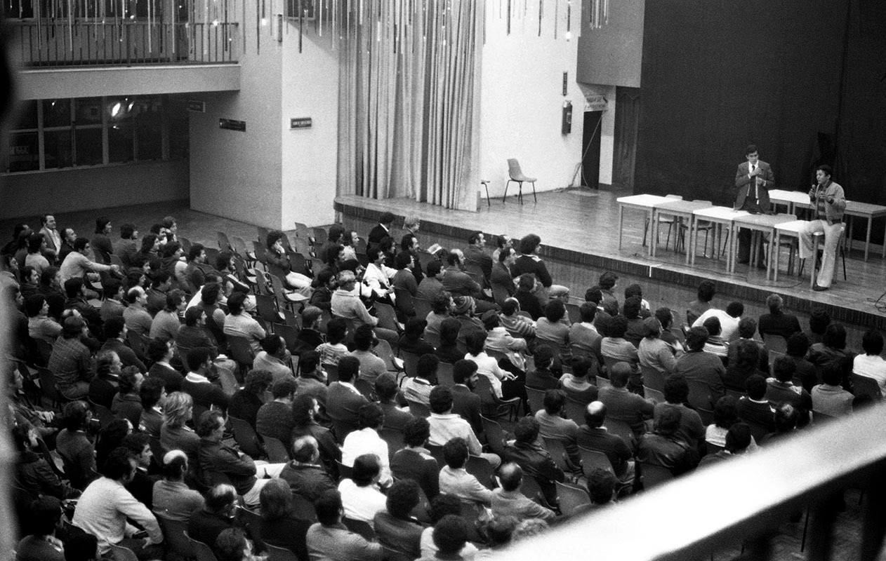Audiência atenta em debate ou palestra política.