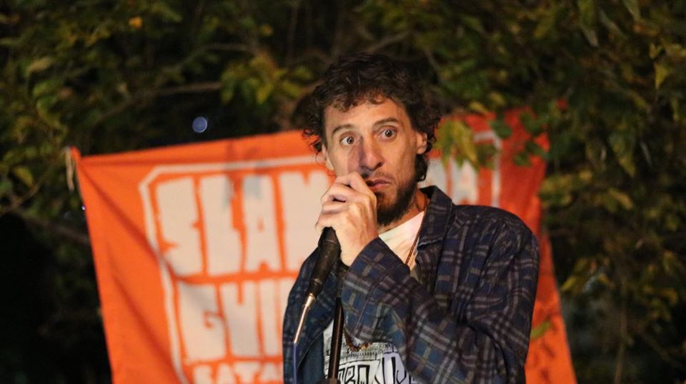 Orador com microfone em evento noturno: paixão e engajamento.