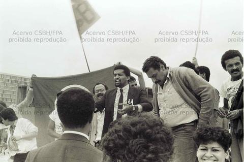 Liderança negra em discurso político com público engajado