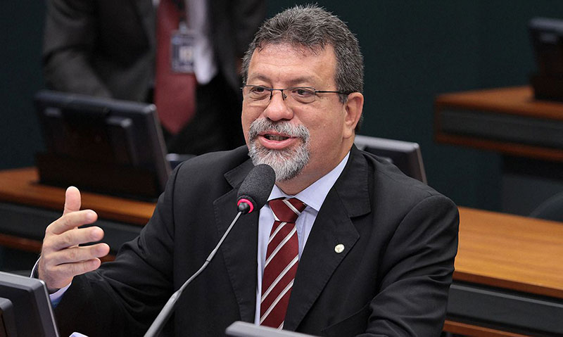 Homem barbudo discursando em evento político formal