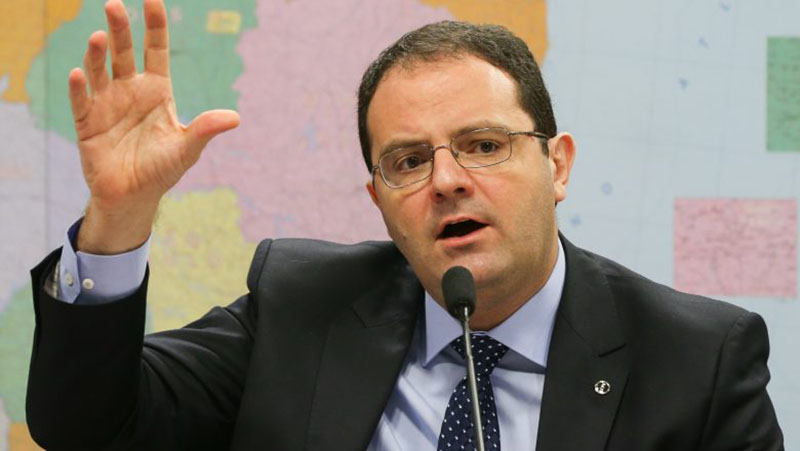 Político discursa com veemência em evento público.