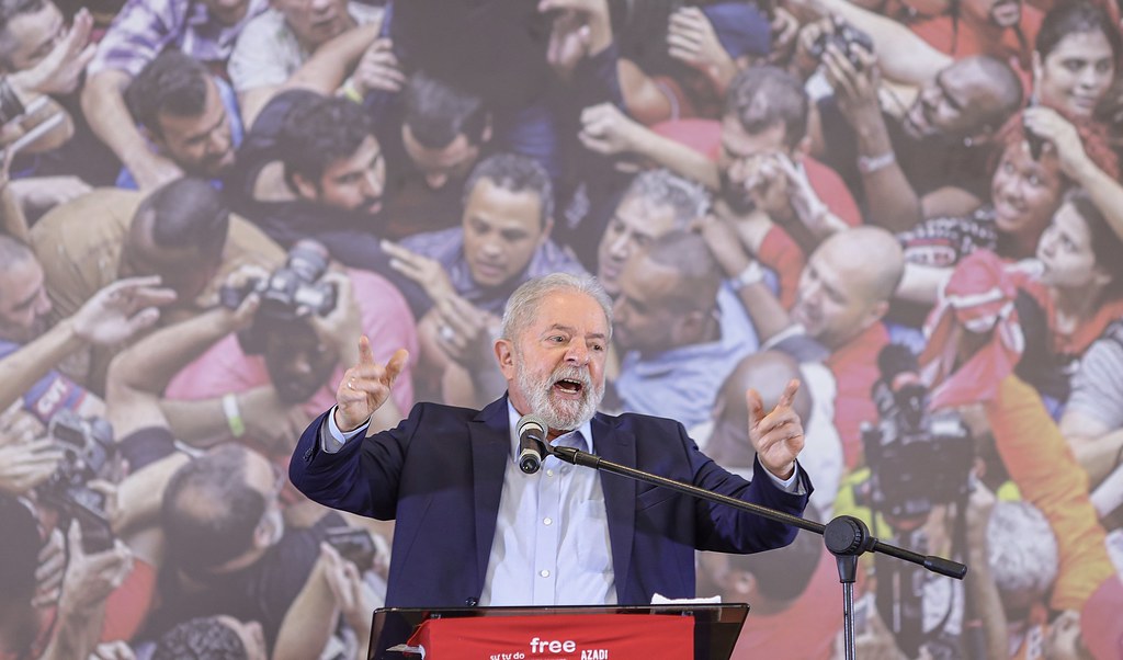 Lula em discurso vibrante cercado por apoio popular.