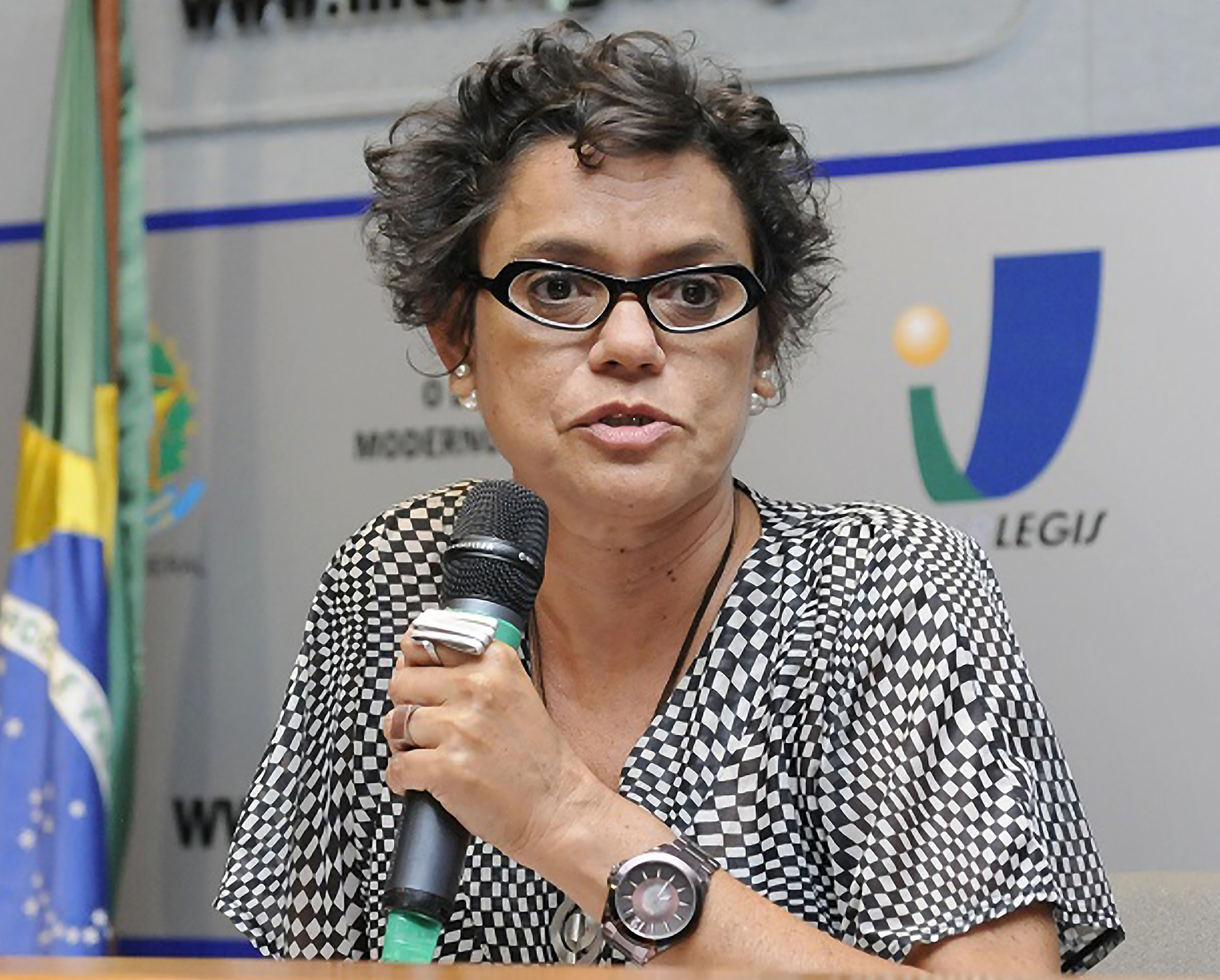 Mulher discursando em evento institucional