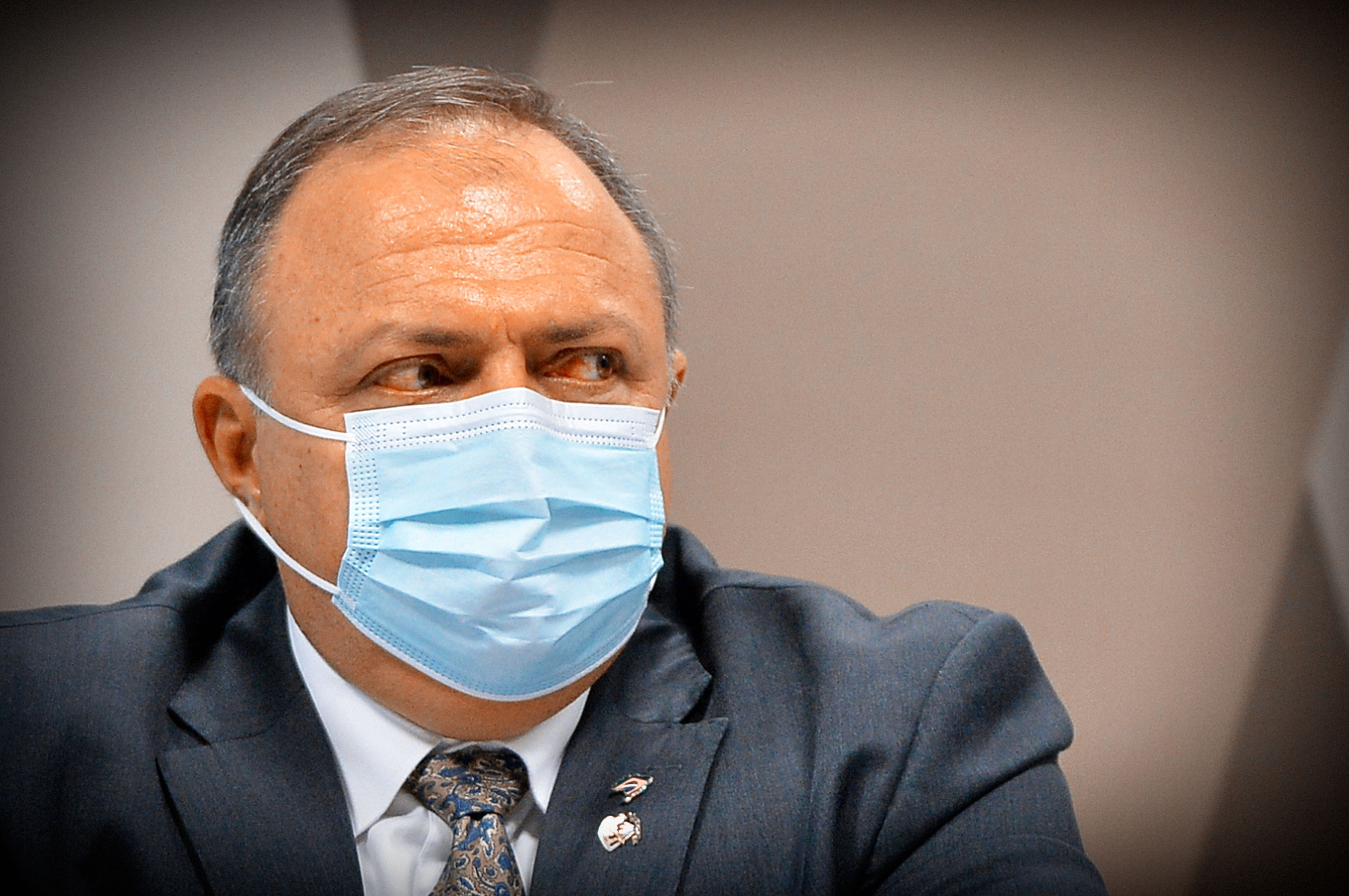 Homem em contexto oficial usando máscara de proteção