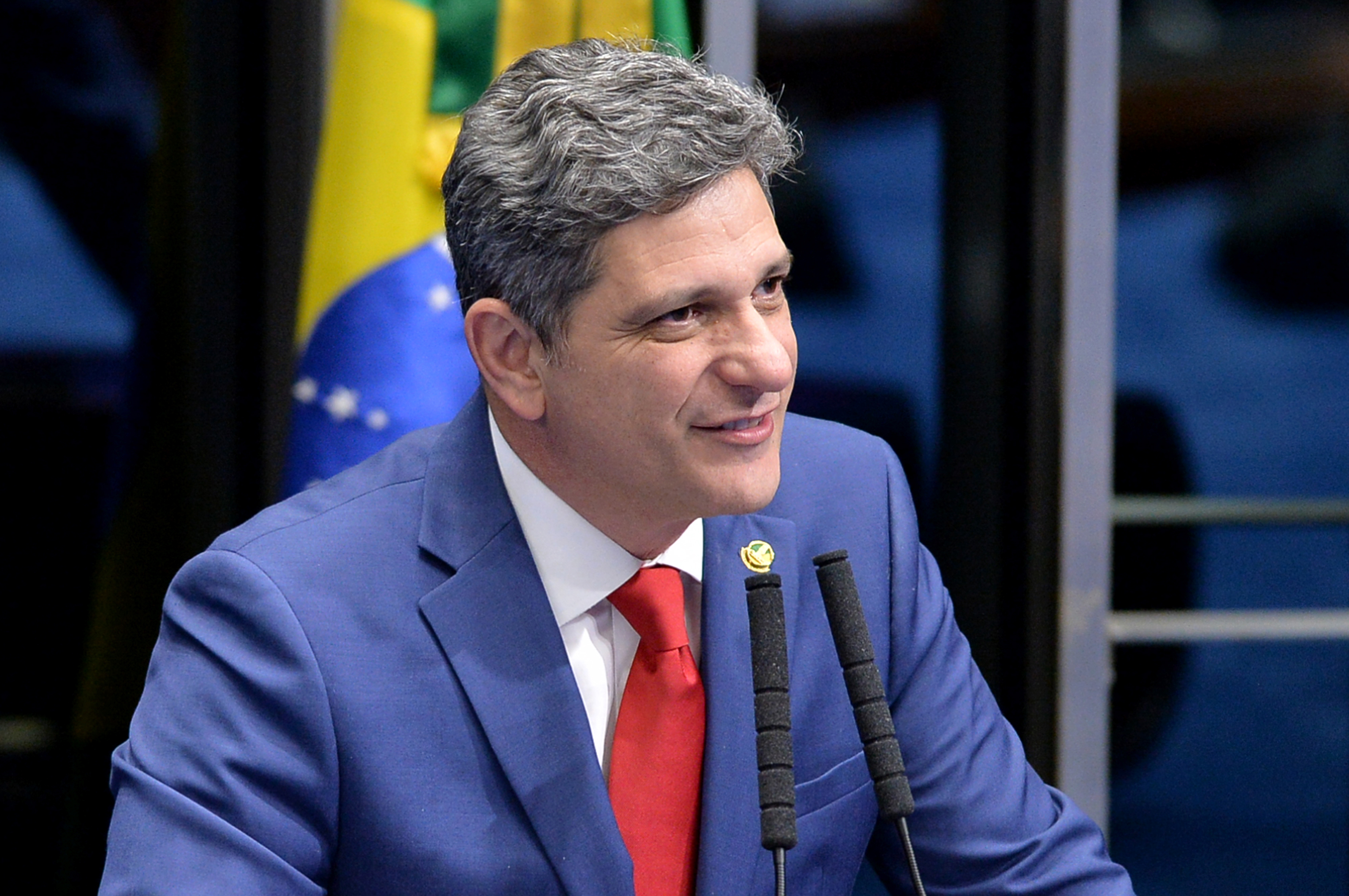 Político Brasileiro Discursa com Bandeira do Brasil ao Fundo