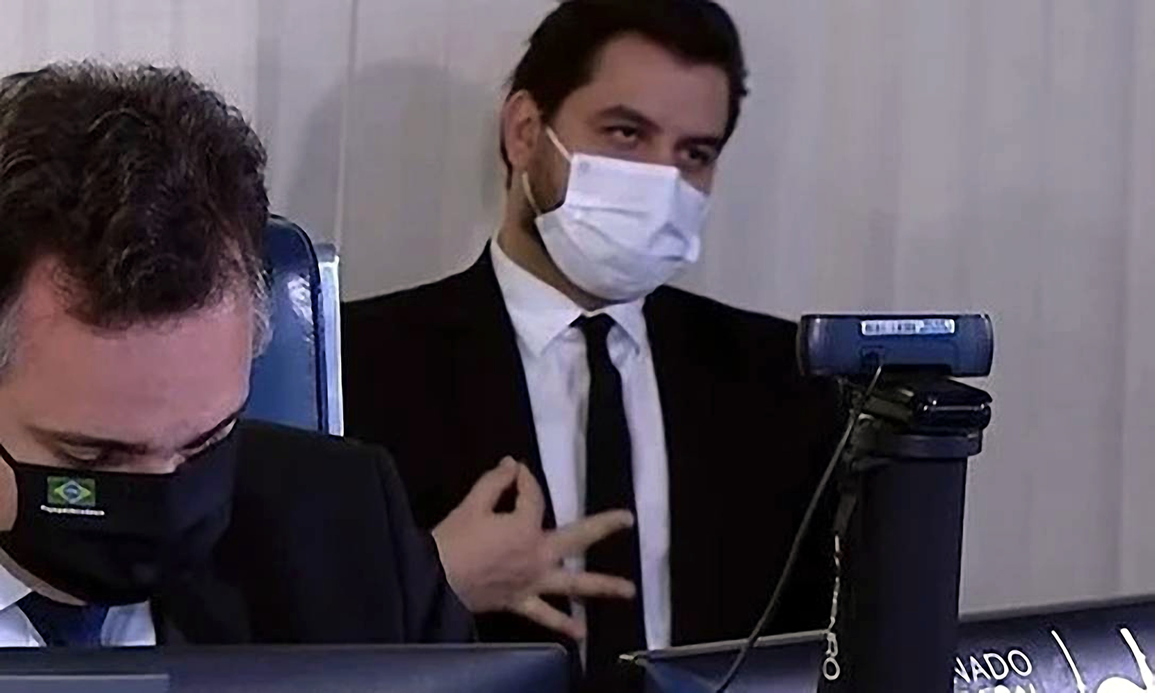 Políticos Mascarados em Sessão Oficial com Gesto Significativo