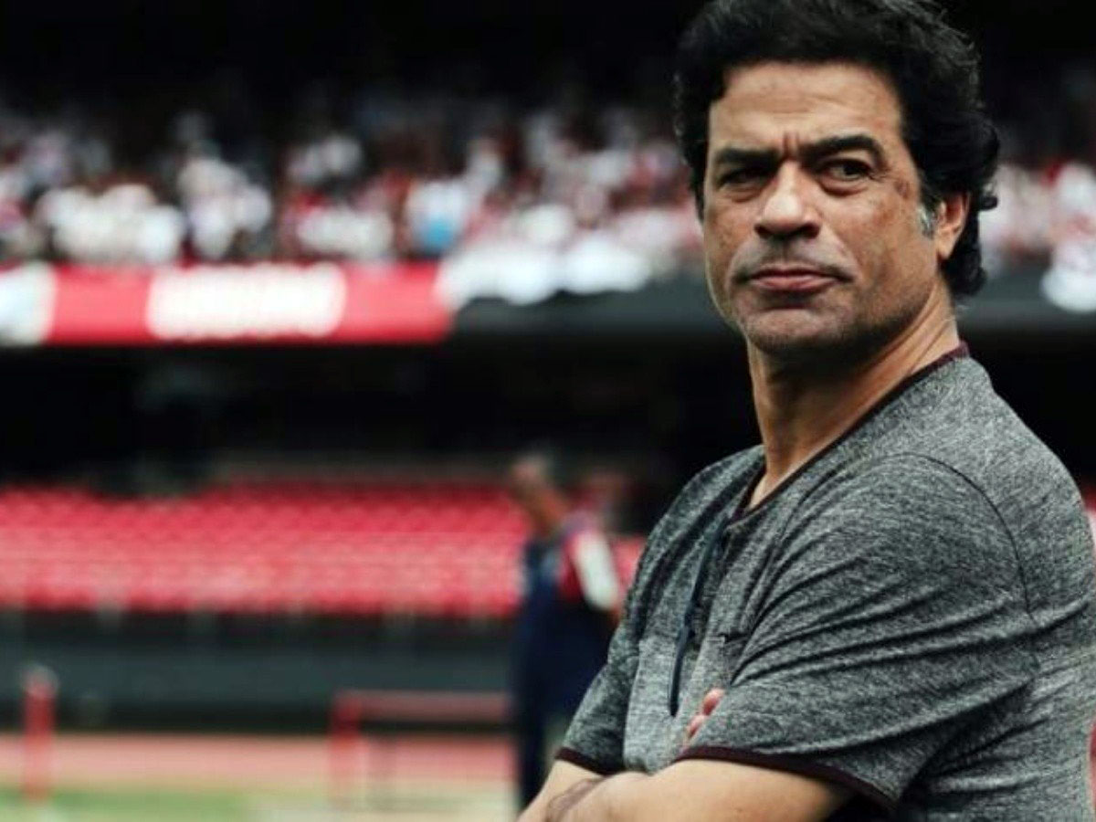 Homem com expressão séria em estádio de futebol